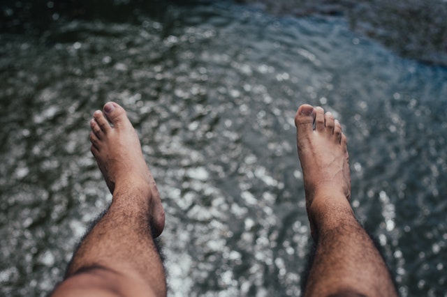 Mens Feet On The Background Of Water