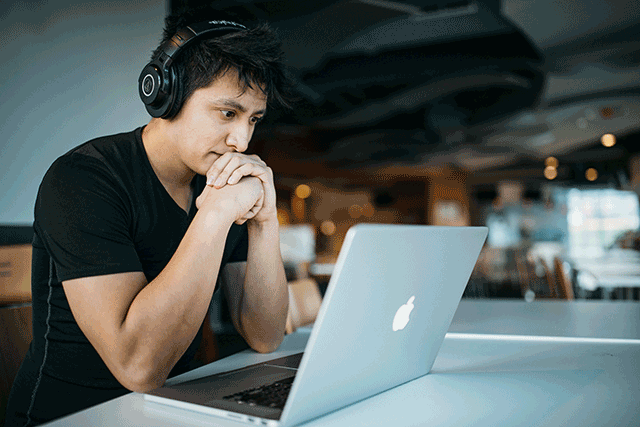 Guy With Headphones On His Laptop